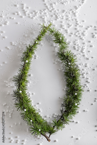 Evergreen trees branch with snow and snowballs in the shape of a circle. Horizontal composition, flat lay, top view. Snow forest creative minimal layout with white background