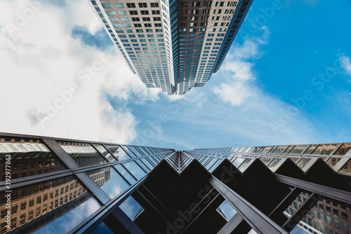 Photography Looking up at the blue sky with skyscrapers and clouds.