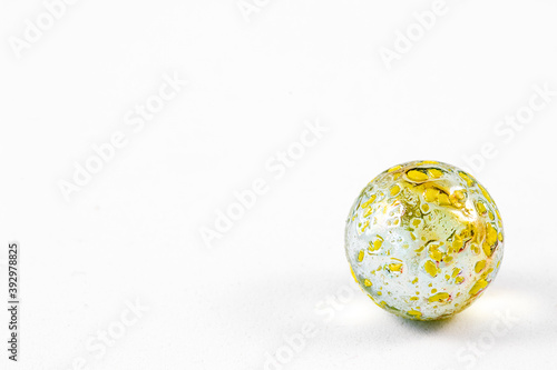 Close up of small yellow speckled glass marble