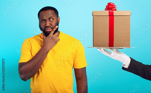 Foto Confused man is suspicious about a gift