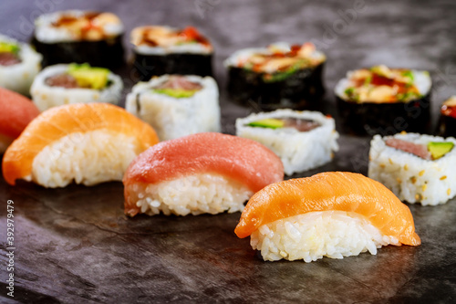 Close up of sushi rolls with red salmon on black background. Japanese food.