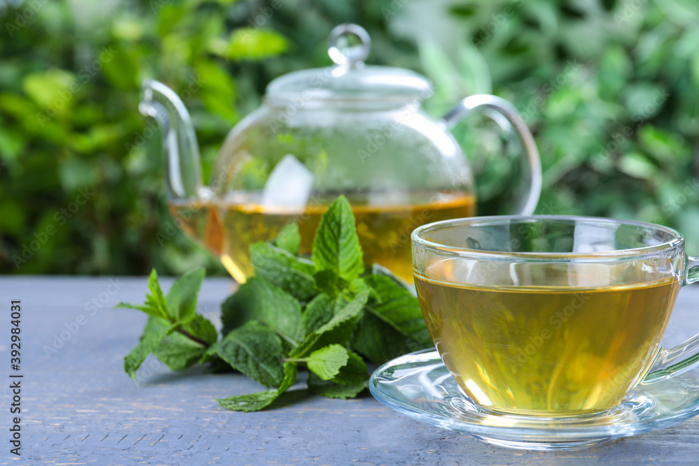 Fresh green tea with mint leaves on light grey wooden table Fresh green tea with mint leaves on light grey wooden table