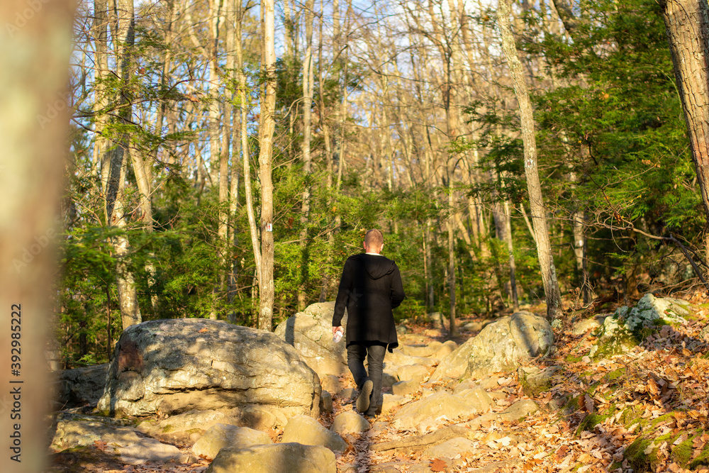 Fototapeta premium A Man Wearing All Black Climbing Up a Mountain Path