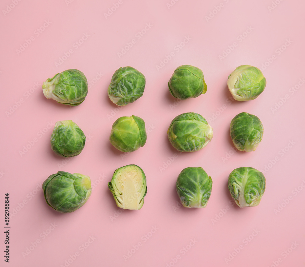 Fototapeta premium Fresh Brussels sprouts on pink background, flat lay