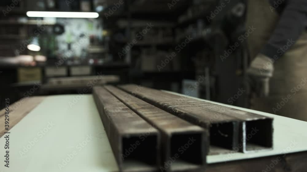 Man works with metal beams in protect gloves. Workshop Man works with metal beams in protect gloves. Workshop