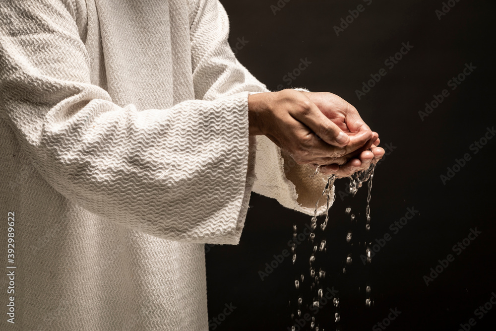 Water for Baptism pouring out of the hands of Jesus Christ during a