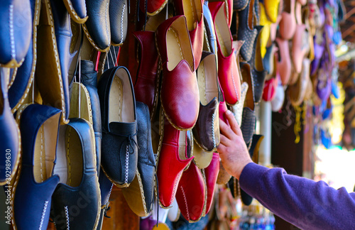 Traditional handmade shoe Yemeni hanging in front of the shop in Gaziantap, Turkey.Turkish leather moccasin shoes made by artisans by hand are offered for sale in the open market Bazaar. photo