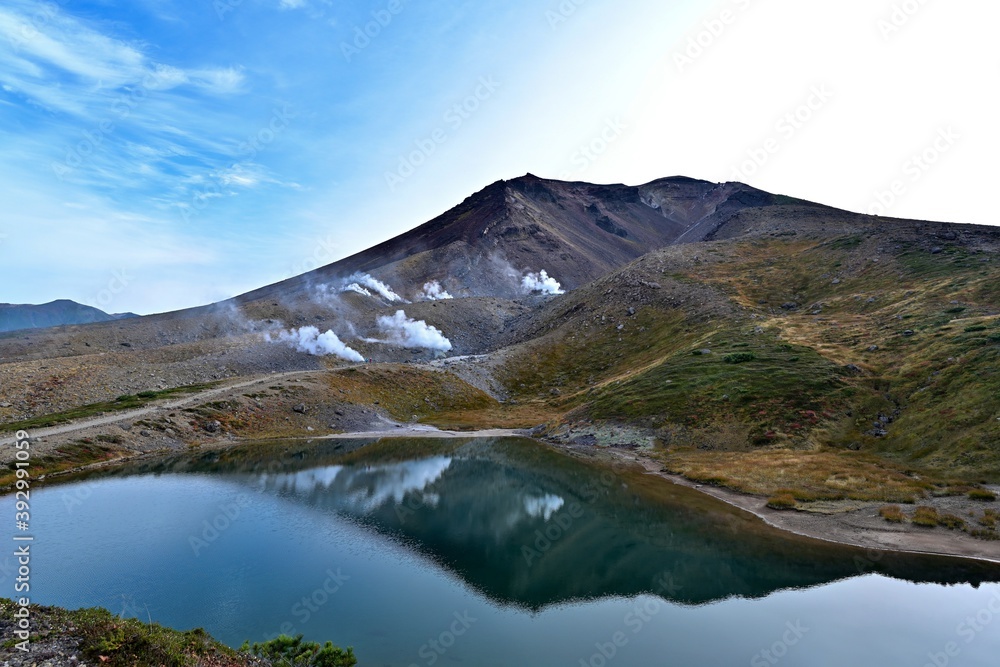 姿見の池に映る活発に噴煙を上げる大雪山旭岳の情景＠北海道