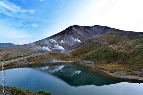 姿見の池に映る活発に噴煙を上げる大雪山旭岳の情景＠北海道
