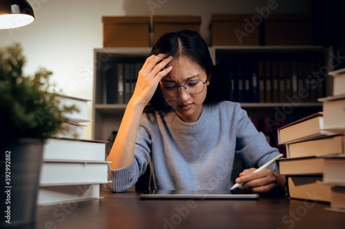 Asian business woman suffers from headache from working with computers for a long time..