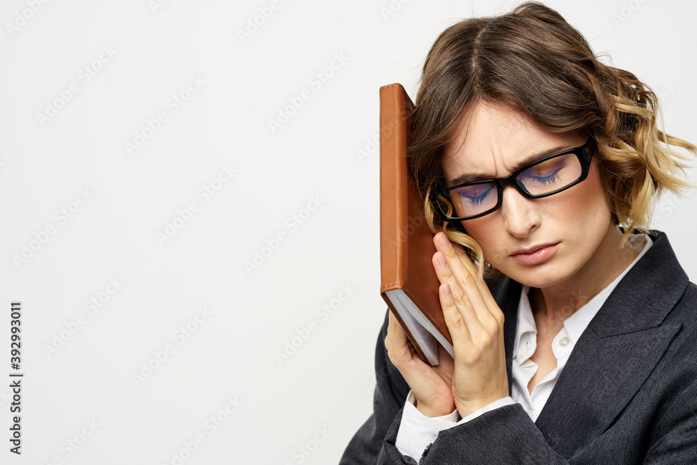 Business woman with notepad and glasses work light background cropped view of suit model. Business woman with notepad and glasses work light background cropped view of suit model.