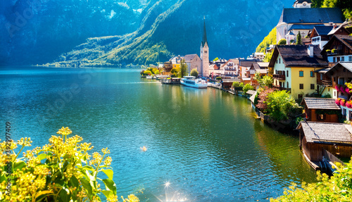 Scenic panoramic view of famous Hallstatt lakeside town reflecting in Hallstättersee lake in the Austrian Alps in scenic light on a beautiful sunny day in autumn, Salzkammergut region, Austria