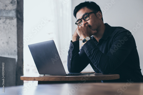 sad depression serious people from work stress concept.asian man feeling tired suffering using computer working work place.concept global economic and health problems © panitan