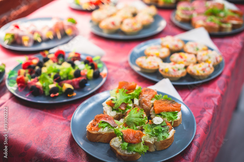 Beautifully decorated catering banquet table with different homemade food snacks and appetizers on corporate birthday party event or wedding celebration, different vegan vegetarian snacks