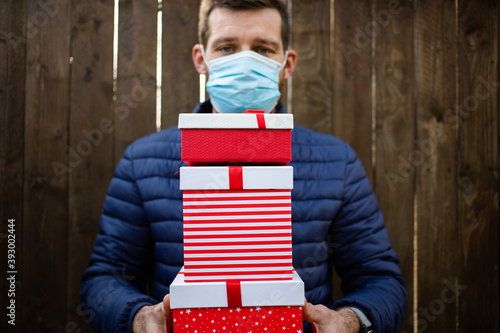 man holding pile of Christmas gift boxes