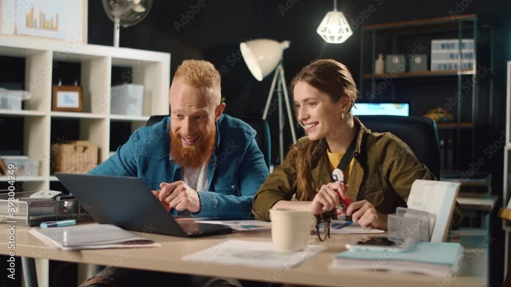 Young businessman and businesswoman working overnight in hipster office. Young businessman and businesswoman working overnight in hipster office.