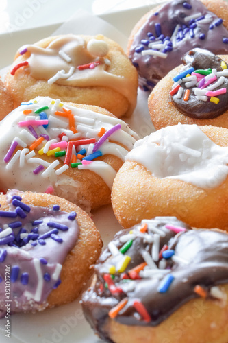 Colorful Assorted Donuts on white plate, Extreme Close up