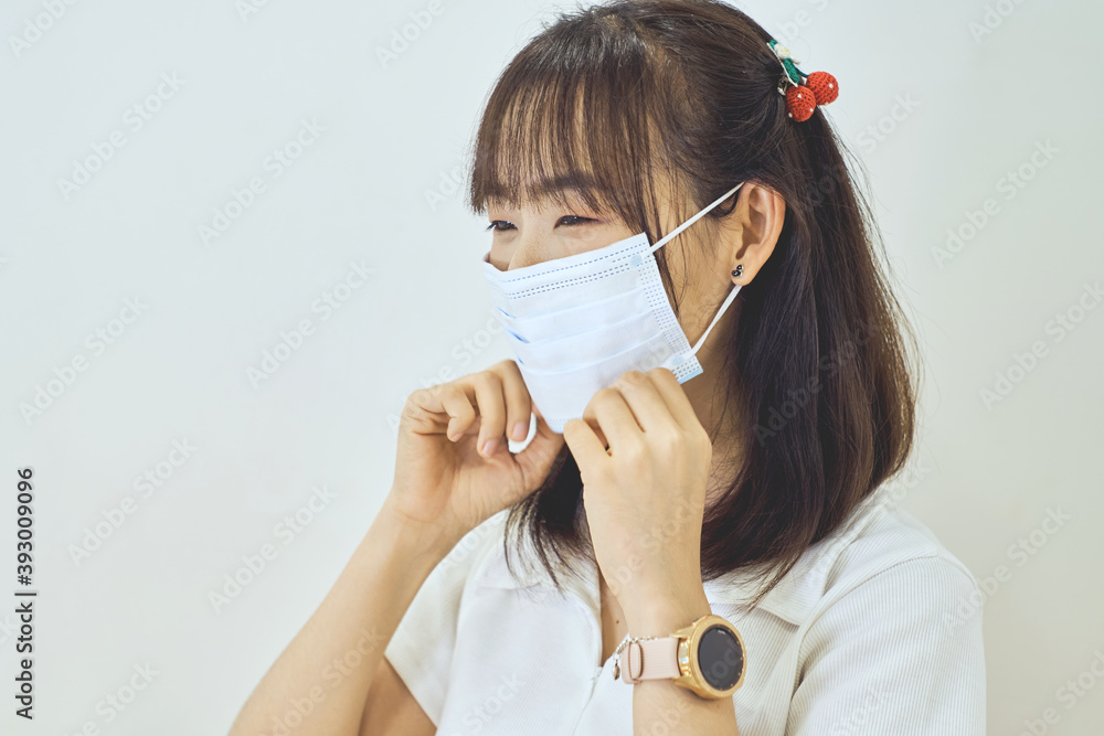 Young happy Asian woman holding hygienic mask with her hand to prevent infection corona virus Young happy Asian woman holding hygienic mask with her hand to prevent infection corona virus