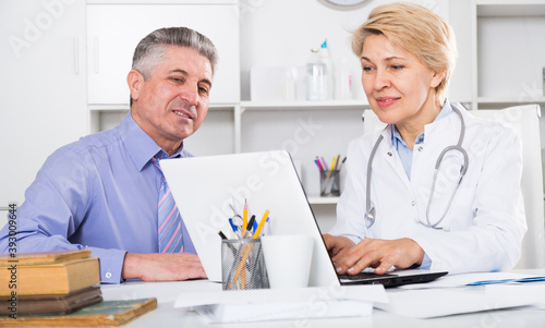 Mature man visiting doctor in clinic office for advice on health