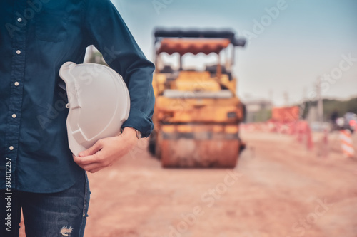 Close up hand holding helmet hard hat Engineering concept, Worker Engineer Standing on road site construction