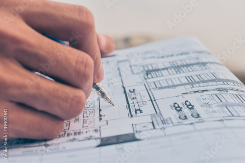 Close up hand write on paper blueprint checking building construction project