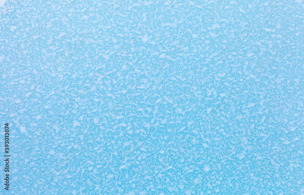 Cold natural background of ice floe surface with frozen crystals of ice and snow on frosty winter day. Blue backdrop of ice texture. Christmas and winter design, mock up, closeup, flat lay, copy space