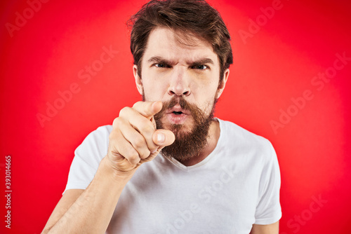 bearded man gesturing with hands white t-shirt emotions facial expression aggression red isolated background