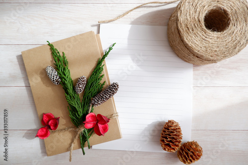 Christmas decoration with craft ribbon and letter papers on white wooden table. photo