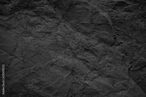 Black stone background. Dark gray rock texture. Rough stone surface with cracks.