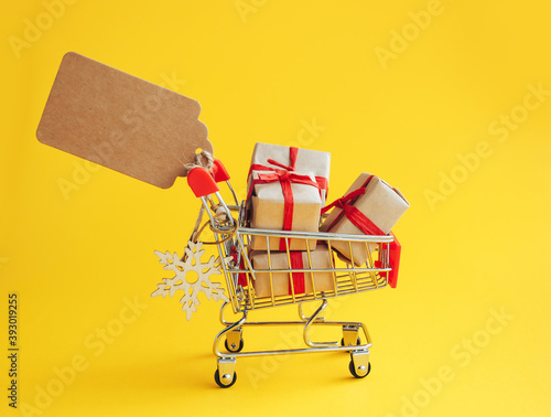 Wallpaper Mural Christmas, New Year and winter sale concept. Shopping cart with gift boxes and blank label for inscription on yellow background. Torontodigital.ca