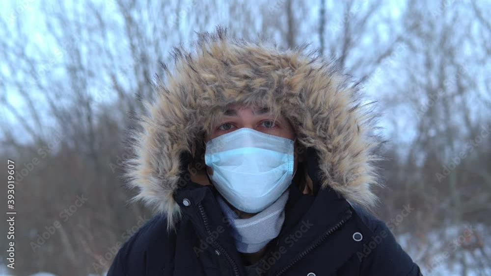 Portrait of a man with wearing a protective medical face mask outdoors in winter. close-up protection from viruses, coronavirus Portrait of a man with wearing a protective medical face mask outdoors in winter. close-up protection from viruses, coronavirus