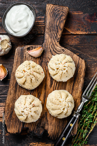 Traditional manti dumplings steamed with mince meat. Dark Wooden background. Top view