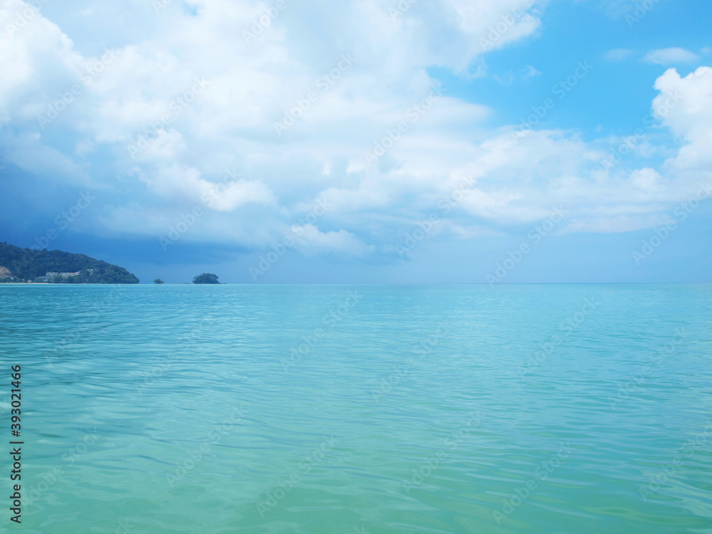 Blue sea, island on a distance on the horizon, azure transparent water. Beautiful sky with clouds. Panorama seascape. Popular resort for a tour tourism. Tropical paradise. View of ocean. Water expance