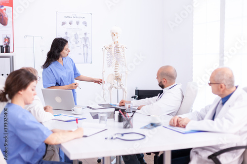 Team of doctors in hospital office setting diagnostic in hospital conference room. Clinic expert therapist talking with colleagues about disease, medicine professional.