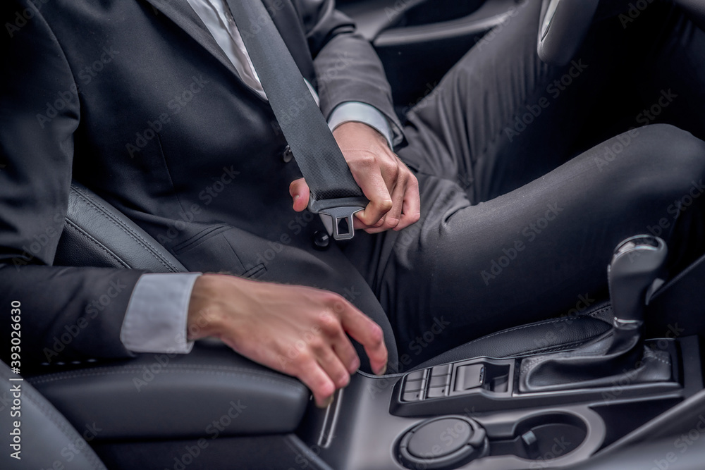 Close-up of driver's hands fastening seat belt