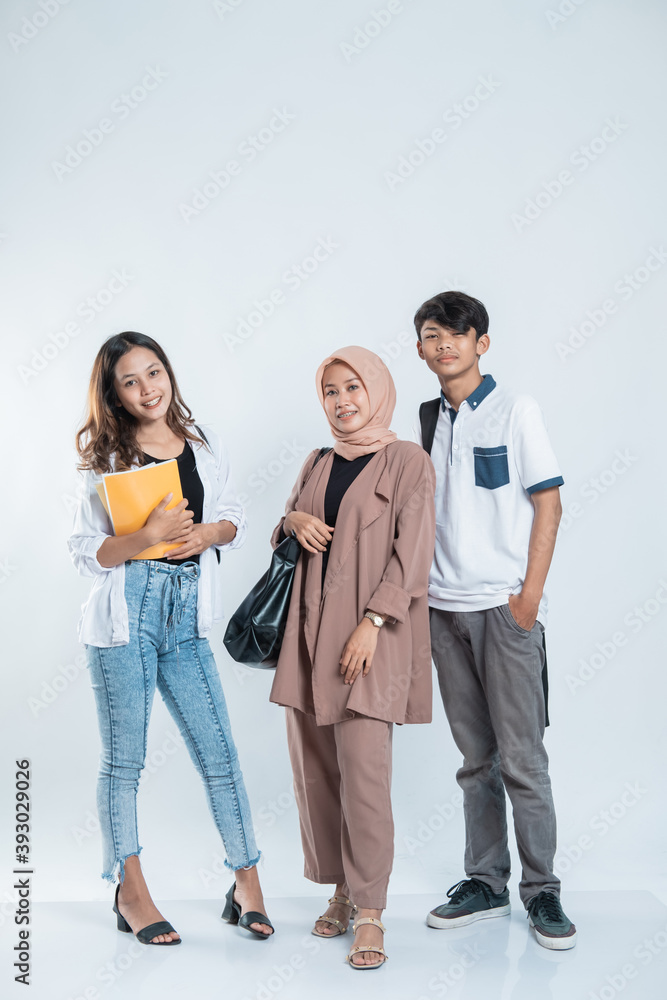 Portrait of Happy College Friends carrying a bag and book on an isolated white Portrait of Happy College Friends carrying a bag and book on an isolated white
