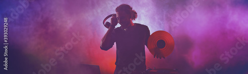 Silhouette of male dj playi...