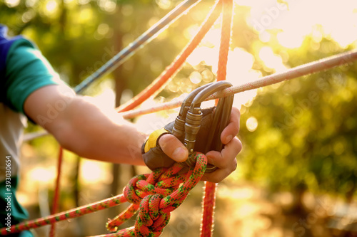 Fototapeta Naklejka Na Ścianę i Meble -  Teenage boy climbing in adventure park