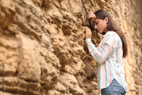 Young woman praying near th...