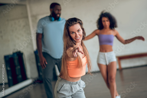 Confident young woman teaching students to dance