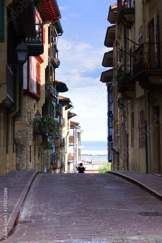 Ruelle étroite dans la ville Hondarrribia en Espagne au Pays Basque, avec un scooter quittant les lieux. photo