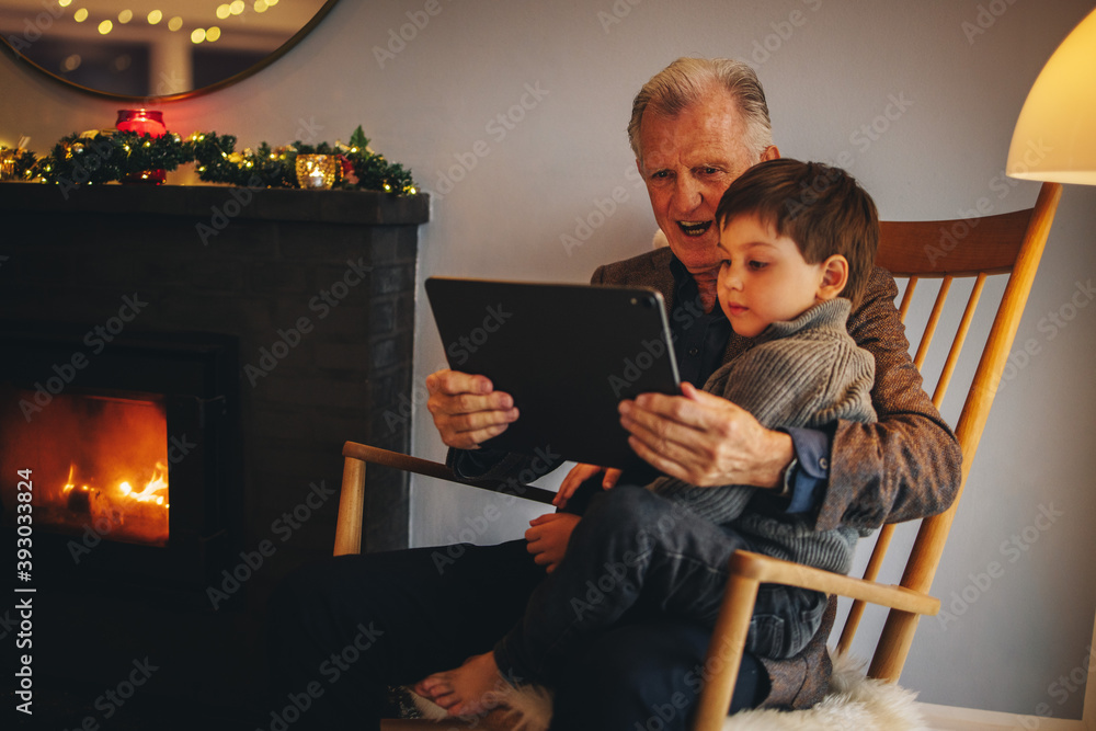Fotografie Grandfather and grandson using a digital tablet