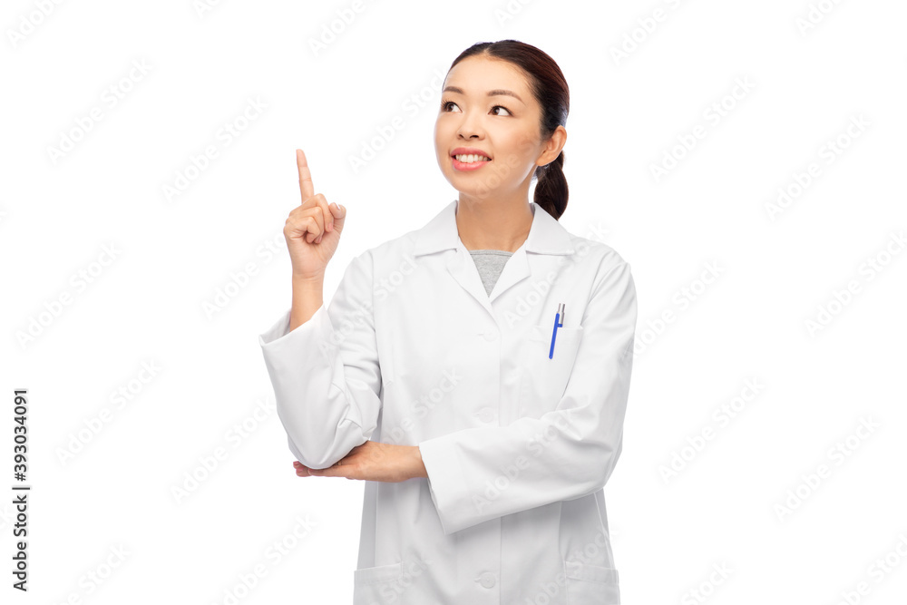 medicine, profession and healthcare concept - happy smiling asian female doctor in white coat pointing finger up medicine, profession and healthcare concept - happy smiling asian female doctor in white coat pointing finger up