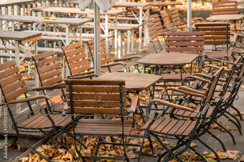 empty beer garden with folding chairs and leaves