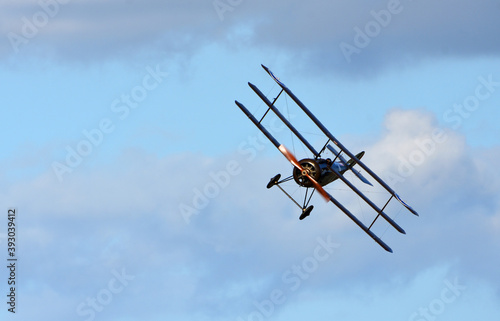 Wallpaper Mural Vintage  Sopwith Triplane  in flight blue sky  and clouds view from front