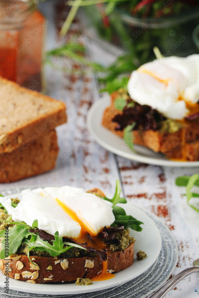 Homemade sandwiches with pesto, green salad and poached eggs	
