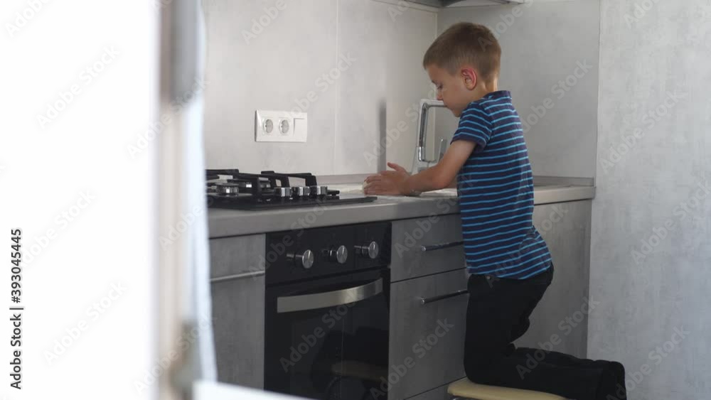 Little boy makes dough in the kitchen. Little boy makes dough in the kitchen.