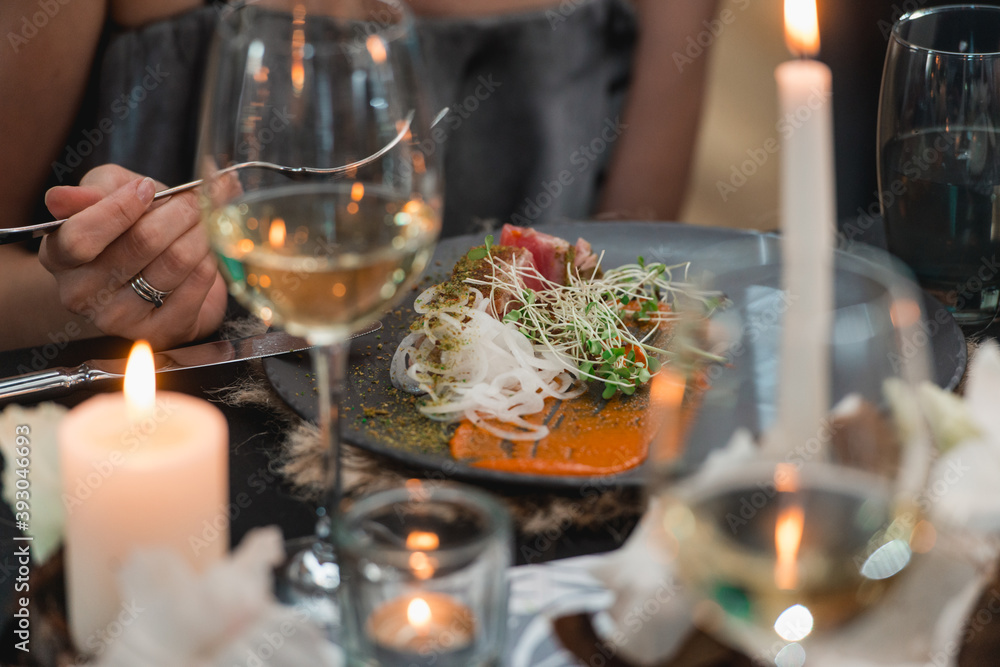 woman eat grilled tuna steak with onion on a grey ceramic plate. Selective focus.