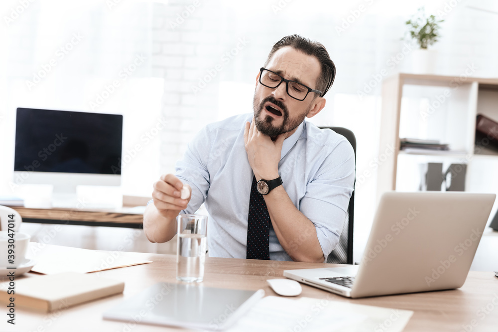 A man at a workplace sits and drops a pill. A man at a workplace sits and drops a pill.