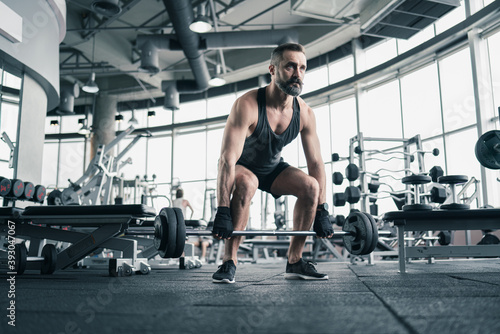 Training in gym, Handsome man with a mustache, do muscle building exercises using dumbbells, focusing on lifting and sit-ups in a fitness sport.
